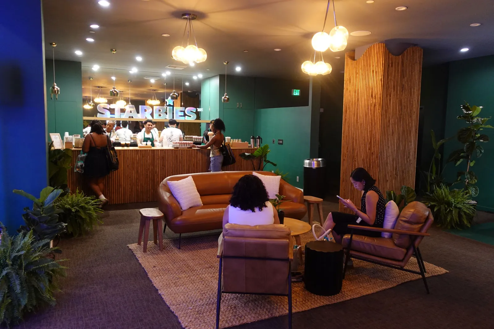 Coffee bar and lounge with leather sofas, plants and pendant lights