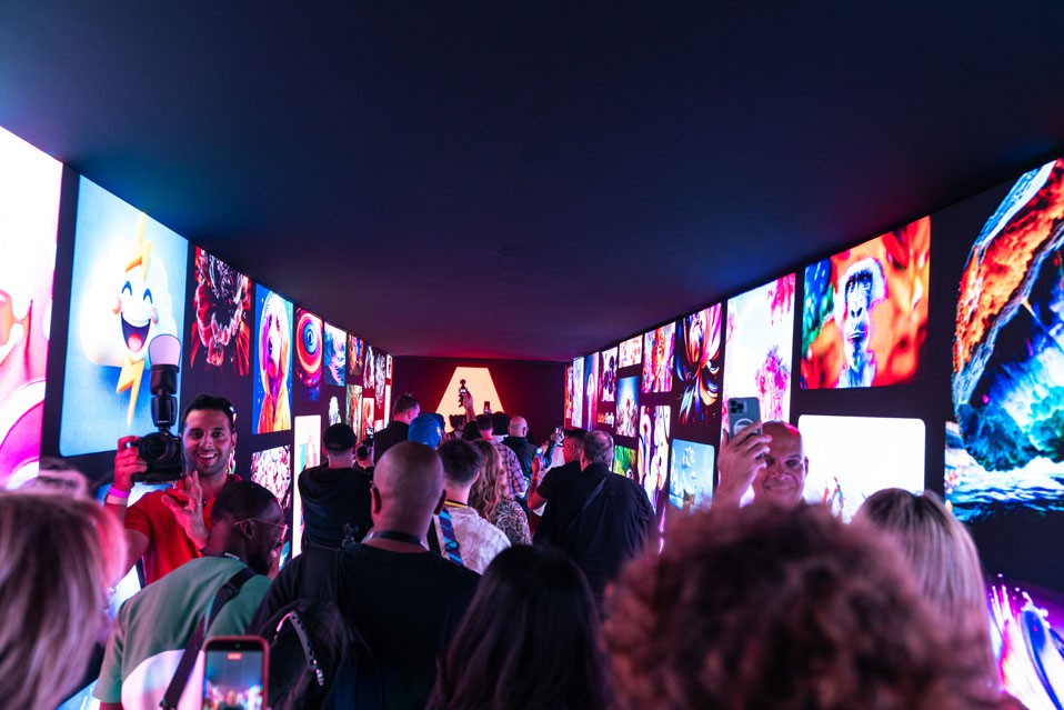 Guests photographing a corridor of glowing art screens